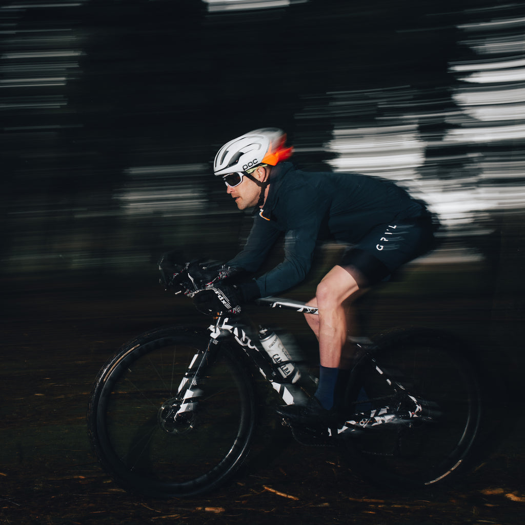 Sustainable gravel cycling apparel in Navy racing through trails by GRVL apparel